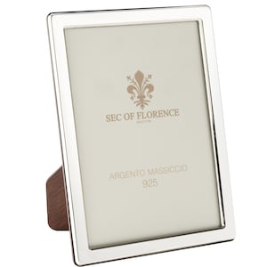 以下が含まれることがあります： 木製のイーゼルバックが付いた長方形の銀色のフォトフレーム。フレームは研磨仕上げで、内側は明るい色です。「SEC OF FLORENCE SINCE 1996」と「ARGENTO MASSICCIO 925」の文字が見えます。