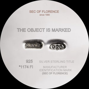 Pode incluir: Um close-up de um objeto prateado com o texto "SEC OF FLORENCE since 1990" e "THE OBJECT IS MARKED". O objeto tem as marca&ccedil;&otilde;es "925", "*1174 FI" e "SILVER STERLING TITLE".