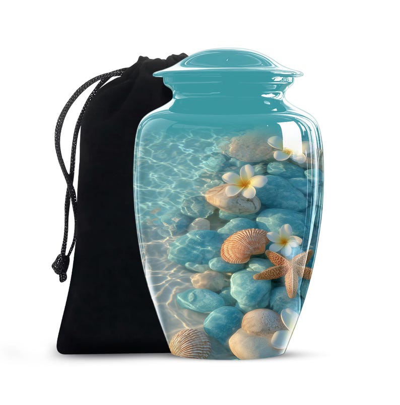 Handmade beach-themed aluminium urn with ocean rocks, shells, and tropical flowers