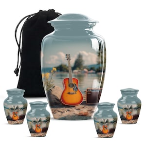 May include: A set of cremation urns and keepsake urns. The large urn is light blue with a scenic image of a guitar on a beach. Smaller urns have the same image. A black velvet bag is included.