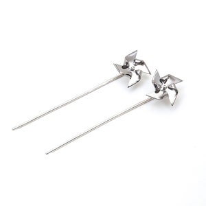 A pair of long pined Pinwheel earrings. They are ear jackets made with Titanium on the pinwheel part and Silver 925 pins and they can actually spin. They are silver colored with polished finish.