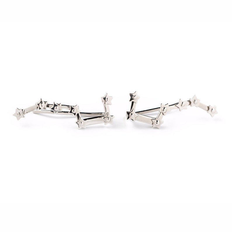 A pair of ear climbers featuring the Big Dipper constellation. Each one has 7 tiny stars on it and these earrings are in solid white gold with polished finish.