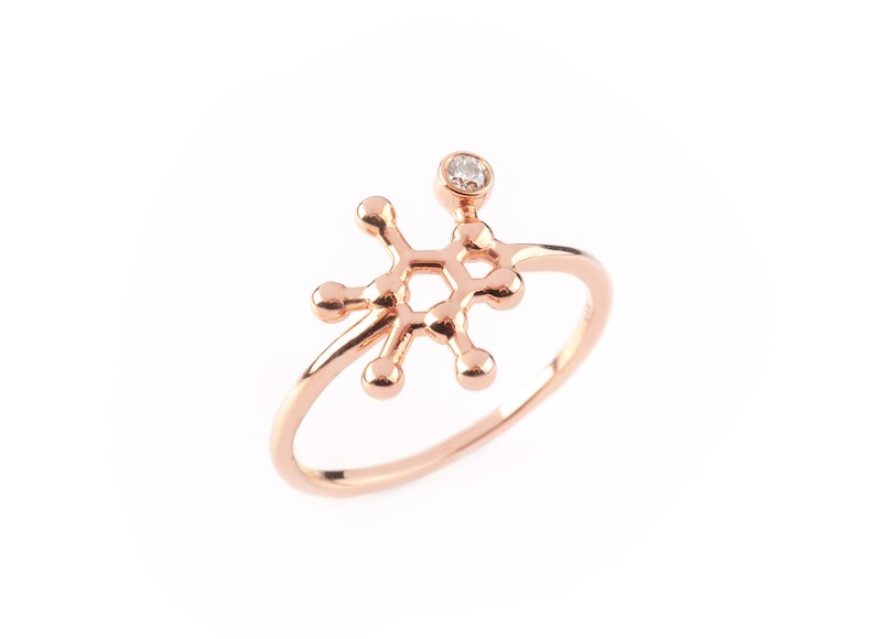 Caffeine Molecule ring in Rose Gold, with a Diamond set on it. Thin rounded ring band with polished finish.