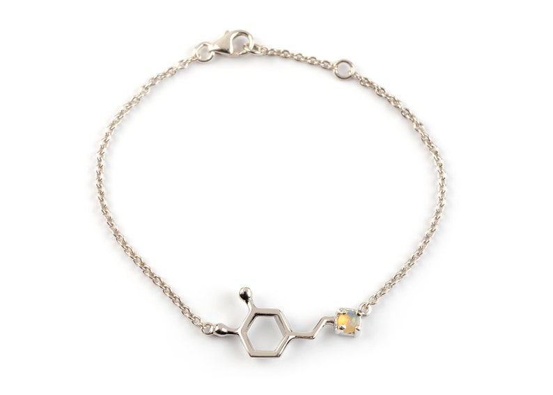 Sterling Silver bracelet of the Dopamine molecule in polished finish. The molecule atom that is on its right end is set with an Opal birthstone.