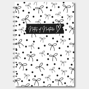 Puede incluir: Un cuaderno de espiral blanco con un patrón de lazos y puntos negros. El texto "Notes of Nurture" se muestra en una pancarta negra, con un símbolo de corazón. El diseño es simple y elegante, ideal para tomar notas.