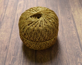 May include: A ball of gold metallic yarn with a shiny finish.