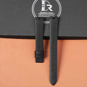 May include: Black watch straps with a textured pattern. The straps are made of a durable material and feature a buckle and multiple holes for adjustment. The brand name "DRWATCHSTRAP" is visible in a circular logo.