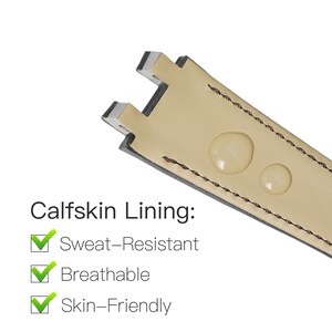 Op de afbeelding: Close-up van een horlogebandje met een beige kalfslederen voering. De band heeft een zwarte rand met bruine stiksels. De tekst "Calfskin Lining" is zichtbaar, samen met vinkjes die zweetbestendige, ademende en huidvriendelijke eigenschappen aangeven.