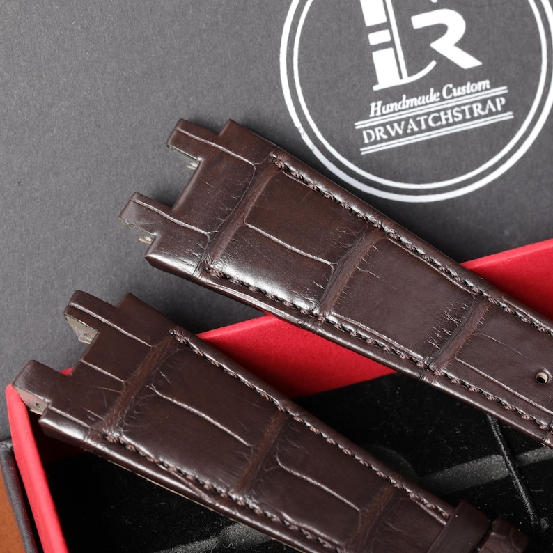 Puede incluir: Dos correas de reloj de cuero marr&oacute;n con textura de piel de cocodrilo. Las correas se presentan en una caja con el texto "Handmade Custom DRWATCHSTRAP" en un c&iacute;rculo blanco.
