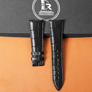 Puede incluir: Dos correas de reloj negras con textura de piel de cocodrilo se muestran sobre un fondo de dos tonos. Las correas son de cuero y tienen un diseño clásico. La parte superior de la imagen presenta un logotipo con el texto "Handmade Custom DRWATCHSTRAP."