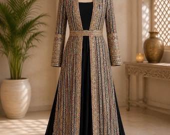 Pode incluir: Um vestido preto até ao chão combinado com um casaco aberto de manga comprida. O casaco apresenta bordados verticais multicoloridos intrincados e detalhes metálicos nos painéis frontais, mangas e um cinto ajustado na cintura.