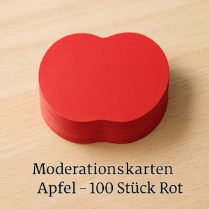 May include: A stack of bright red apple-shaped cards. The cards are neatly arranged on a light-colored wooden surface. The text "Moderationskarten Apfel - 100 Stück Rot" is printed in black at the bottom of the image.
