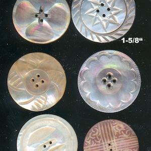 May include: Six circular mother-of-pearl buttons with various carved patterns and hole configurations. The top right button measures 1-5/8 inches in diameter, and the bottom right button measures 1-3/8 inches. Text reads Lot#2627a.