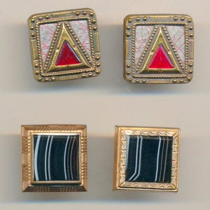 May include: Four square cufflinks. The top two have a gold-colored border with a red triangle in the center. The bottom two have a gold-colored border with a black and white striped design.