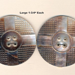 May include: Two large, round buttons with a cross-hatch design and a smaller button in the centre. Each button is approximately 4.4 cm in diameter. The buttons are a mix of brown and tan colours.