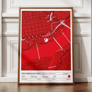 Può includere: Una mappa rossa e bianca incorniciata di Cincinnati, Ohio, con il Great American Ball Park. La mappa include i dettagli delle strade e la posizione dello stadio. La parte inferiore della cornice presenta il testo con la capacità dello stadio, la data di apertura, la città e lo stato.