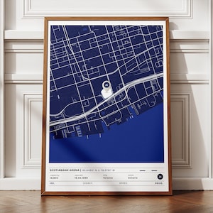 May include: A framed print featuring a detailed white map of a city over a deep blue background. The map includes roads, buildings, and a prominent marker. The print is labeled "Scotiabank Arena" with coordinates and other details.