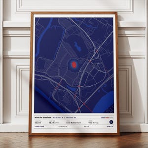 May include: A framed print of MetLife Stadium, rendered in a detailed blue and white map design. The stadium is highlighted in red, with text at the bottom indicating the stadium's name, location, and capacity. The frame is a warm brown.