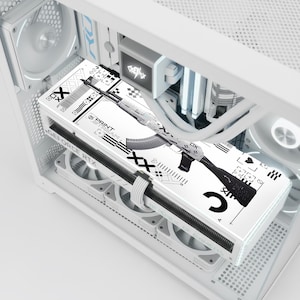 May include: A white computer case with internal components, including fans and a graphics card. The graphics card has a white and black design featuring a stylized rifle and the text "PRINT TEAM". The case has a clean, modern aesthetic.
