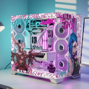 May include: A white computer case featuring custom graphics of a blue-haired character, pink graffiti-style text reading "BANG!" and "YOU'RE A JINX," and internal components illuminated by purple and white lighting, with a clear glass side panel.
