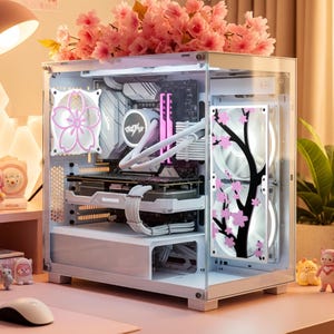 May include: A white computer case with a clear glass side panel, featuring a floral design and pink accents. The case has a cherry blossom theme, with pink flowers and a black tree design on the fan. The computer is decorated with pink flowers.