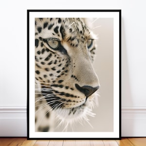 Puede incluir: Impresión enmarcada que muestra un primer plano de la cara de un leopardo de perfil. El pelaje del leopardo es de color canela con manchas negras. El ojo del animal es de color verde claro y su nariz es negra. La impresión está en un marco negro.