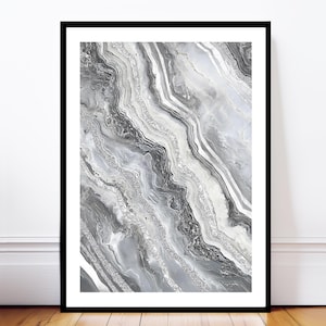 Könnte beinhalten: Gerahmter Kunstdruck mit abstraktem Design. Das Kunstwerk zeigt ein marmorähnliches Muster in Grau-, Weiß- und Silbertönen. Diagonale Linien und Glitzerakzente erzeugen ein strukturiertes, fließendes Muster. Der Druck wird vor einer weißen Wand und einem Holzboden präsentiert.