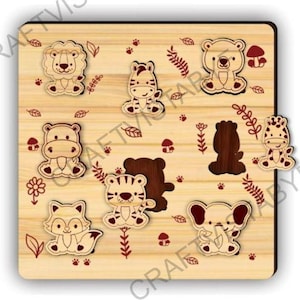 May include: Wooden animal puzzle featuring a lion, zebra, bear, hippo, fox, tiger, elephant, and giraffe. The puzzle pieces are light brown with dark brown outlines and details. The base is light brown with red decorative elements.