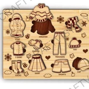 May include: Wooden puzzle featuring clothing items like a coat, sweater, trousers, and shorts. The puzzle pieces are light brown with darker brown outlines. Other pieces include a hat, scarf, gloves, and socks. The word "SWEATER" is visible.