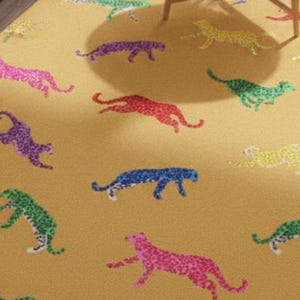 May include: A mustard-colored rug featuring a repeating pattern of colorful cheetahs. The cheetahs are depicted in various colors, including pink, purple, blue, green, and yellow. The rug is likely made of a soft material.