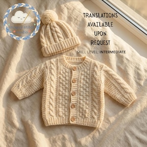 Op de afbeelding: Een crèmekleurig gebreid babyvest met een kabelpatroon en vijf houten knopen, gecombineerd met een bijpassende muts met pompon. De afbeelding bevat de tekst: TRANSLATIONS AVAILABLE UPON REQUEST, SKILL LEVEL: INTERMEDIATE, en een logo.