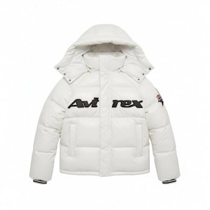 Könnte beinhalten: Weiße Steppjacke mit Kapuze. Auf der Brust der Jacke steht der schwarze Schriftzug "Avi rex", und auf dem rechten Ärmel befindet sich ein kleines Emblem. Die Manschetten haben schwarze Streifen.