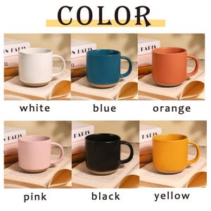 Peut inclure: Six tasses en c&eacute;ramique de diff&eacute;rentes couleurs : blanc, bleu, orange, rose, noir et jaune. Chaque tasse a une forme arrondie, une anse et une base marron clair. Le mot "COLOR" est en haut.