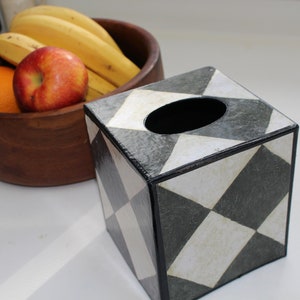 May include: A black and white geometric tissue box cover with a diamond pattern. The cover is made of a textured material and has a black border.