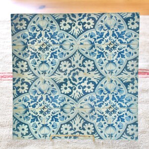 May include: A square ceramic tile with a blue and white floral pattern. The tile is made up of nine smaller squares, each with a different design. The tile is perfect for adding a touch of traditional style to any room.