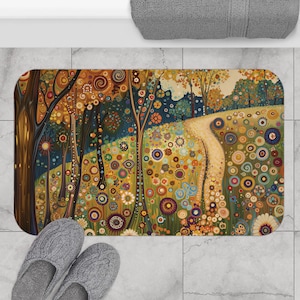 May include: A rectangular bath mat featuring a colorful, artistic landscape design. The artwork depicts a path winding through a forest with trees and flowers in shades of orange, yellow, green, and blue. Gray slippers are at the bottom.