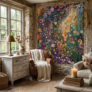 May include: A cozy living room with a large, colorful floral painting as a focal point. The room features a distressed white dresser, a leather armchair with a cream-colored blanket, and a lit candle on a stack of books. A warm and inviting space.