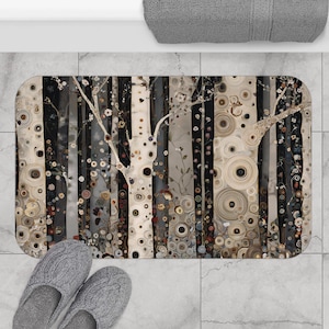 May include: Rectangular bath mat featuring a stylized forest scene with vertical stripes in black, white, and gray. The design includes circular patterns and tree branches with small flowers. Gray slippers are placed near the mat.