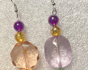 Pendientes colgantes grandes de cristal en tonos melocotón claro y rosa con destellos amarillo brillante y morado brillante. 4,4 cm de largo.