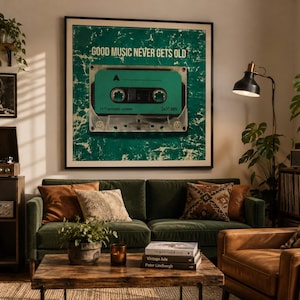 Op de afbeelding: Een vierkante ingelijste muurkunstprint met een groenblauw cassettebandje in het midden op een verweerde donkergroene achtergrond met de tekst GOOD MUSIC NEVER GETS OLD, HI FI compact cassette en 2x30 MIN in wit en zwart.