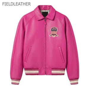 Puede incluir: Chaqueta de cuero rosa brillante de estilo bomber cl&aacute;sico. Cuello camisero, cierre de cremallera y parche en el pecho. Los pu&ntilde;os y el dobladillo tienen rayas blancas y crema. El texto "FIELDLEATHER" est&aacute; en la parte superior.