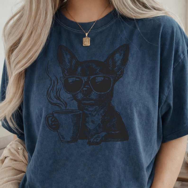Puede incluir: Camiseta azul oscuro con un gr&aacute;fico negro de un chihuahua con gafas de sol y sosteniendo una taza de caf&eacute;. El perro est&aacute; representado con vapor saliendo de la taza. La camiseta tiene un aspecto vintage.