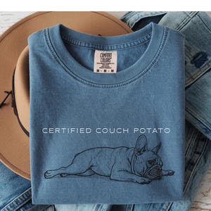 Beige hoodie featuring a sketch of a sleeping French Bulldog.