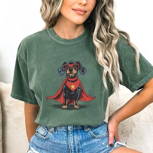 Illustration of a black and tan wiener dog wearing a red eye mask and a red cape.