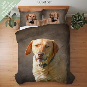 Peut inclure: Ensemble de literie avec une grande image d'un Labrador Retriever jaune. L'ensemble comprend une housse de couette et deux taies d'oreiller, toutes avec le même portrait de chien. Le texte "Look forward to making your bed every day!" est en haut à gauche.