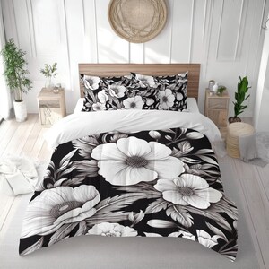 May include: A black and white floral bedding set featuring large, stylized white flowers and foliage. The duvet cover and pillowcases showcase a bold, graphic design, creating a striking contrast against the white sheets. The set includes a duvet cover and pillowcases.