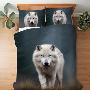 May include: A bedding set comprising a duvet cover and two pillowcases with a dark, moody background. The design features a large, white wolf walking through tall grass on the duvet, with a matching white wolf portrait on each pillowcase.