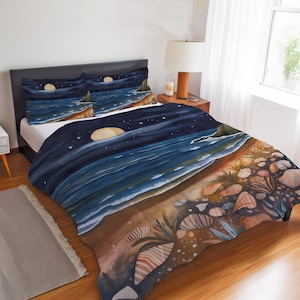 May include: Watercolor bedding set featuring a beach scene at night. The design includes a full moon, ocean waves, and seashells. The set includes a duvet cover and two pillowcases, creating a coastal theme.