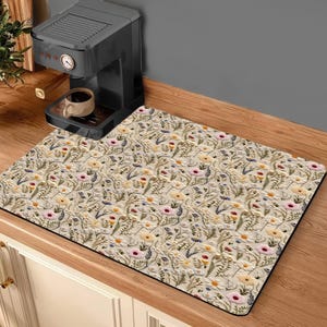 May include: A beige kitchen mat with a floral pattern featuring small pink, yellow, and red flowers. The mat is made of a durable material and is perfect for protecting your kitchen floor from spills and stains.