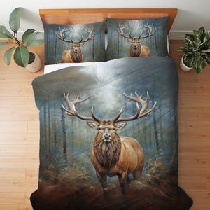 May include: A bedding set featuring a majestic elk with large antlers in a forest setting. The duvet cover and two pillowcases display the elk against a backdrop of trees and a misty sky. The color palette includes shades of brown, blue, and green.